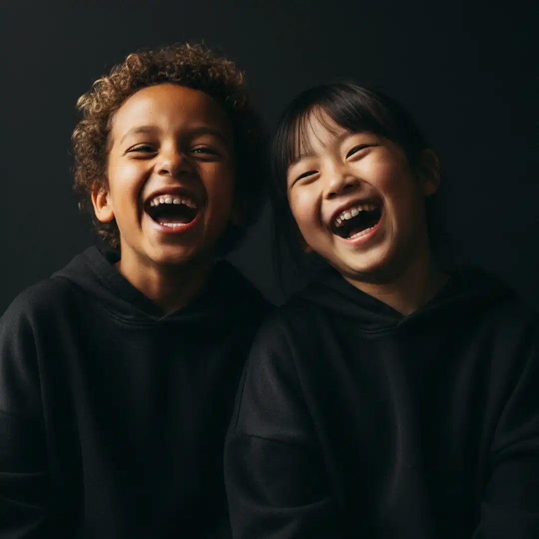 Kinderlachen, ein Kleinkind stützt sich auf die Ellenbogen und lacht freudig in die kamera