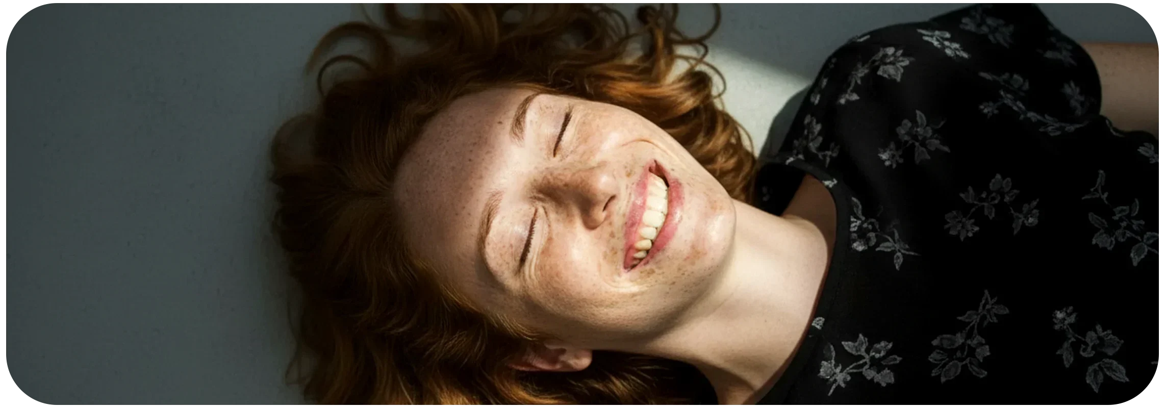 Eine glückliche junge Frau liegt auf dem Boden und ist lächelt